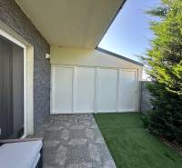 The terrace of a family house in Gabčíkovo with seating, paving, and artificial grass.