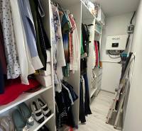 A wardrobe in a family house with clothes, shoes, and storage spaces.