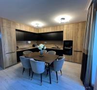 A kitchen in a family house with wooden furniture and a dining table.
