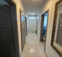 A hallway in a family house with wooden flooring and modern lighting.