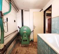 Boiler room with a bathroom in a family house with retro tiles and equipment.