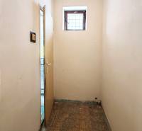 Narrow room with a small window and open door in a family house.