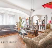 Living room with leather sofas and a wooden staircase in a family house.