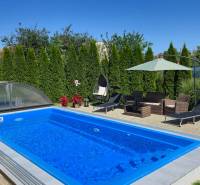 A swimming pool with a garden seating area and loungers in a family house in Trenčianske Jastrabie.