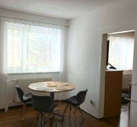 Dining room in a family house with a window, a table and four chairs, white walls.