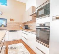 A kitchen in a family house with modern appliances and a large window.
