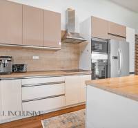 Modern kitchen in a family house with a wooden countertop and appliances.