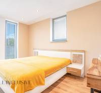 Bright bedroom with wooden floor and yellow blanket in a family house.
