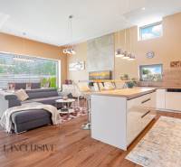 Living room in a family house with a kitchen, gray sofa, and dining table.