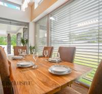 Dining room in a family house with a wooden table, set with dishes and a view of the terrace.