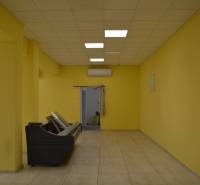 Yellow walls, tiles, and ceiling lights in commercial spaces.