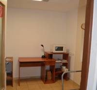 Interior of commercial space with a simple desk and a microwave oven.