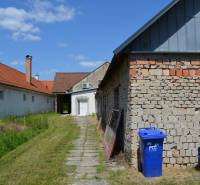 Commercial premises in Borský Svätý Jur, buildings with red roofs, lawn, and a blue container.