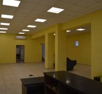 Interior of commercial spaces with a striking yellow wall and ceiling lights.