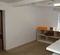 Interior of commercial spaces with shelves and a window covered with blue fabric.
