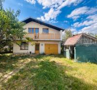 A family house in Sobrance with a garden and an outbuilding under the blue sky.