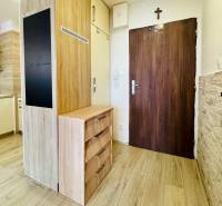 Entrance area in a 2-room apartment with wooden flooring and a kitchenette.