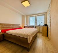 A bedroom in a two-room apartment with a comfortable bed and wooden floors.