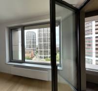 The interior of a 2-room apartment includes open windows with a view of modern buildings.