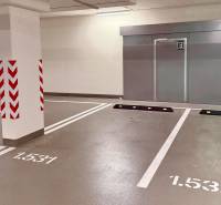 Underground parking garage with marked spaces and safety features for cars.