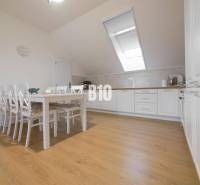 Dining room in a 3-room apartment with a dining table, chairs, and a kitchen unit.