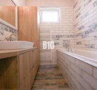 A bathroom in a 3-room apartment with a bathtub, a sink, and decorative tiles.
