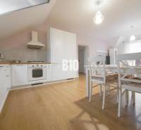 Open kitchen with a dining table in a 3-room apartment, light wooden floors.