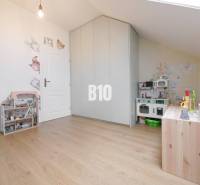 Children's room in a 3-room apartment with a wardrobe, toys, and decorative wallpaper with animals.