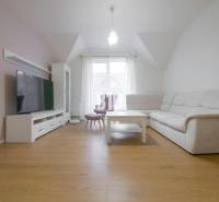 A bright living area in a 3-room apartment with a television and a comfortable sofa.