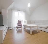 Living room in a 3-room apartment with a sofa, an armchair, a table, and a television.