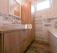 Bathroom in a 3-room apartment with wooden furniture and decorative tiles.