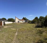 Plots - housing in Veľký Meder with grassy area and nearby buildings.