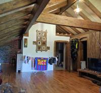 Wooden beams and flooring in a 2-room apartment with a relaxing interior, masks on the wall.