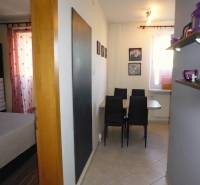 Dining area with chairs and a shelf in the entrance of a 3-room apartment.