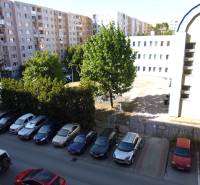 Parking lot and apartment buildings on Lomnická Street in Prešov, surrounded by greenery.