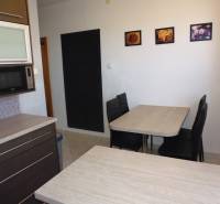 Dining area with dark furniture and pictures on the wall in a 3-room apartment.