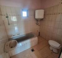 A bathroom in a family house with a bathtub, sink, toilet, and boiler.