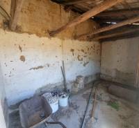 The interior of a family house with damaged walls and old construction equipment.