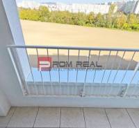 The balcony of a 2-room apartment on Labutia Street, Bratislava V with a view of greenery and buildings.