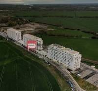 Buildings on Labutia Street in Bratislava V surrounded by greenery and fields.
