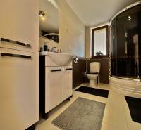 Bathroom in a family house with a bathtub, sink, and storage space.