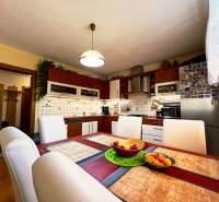 Kitchen in a family house with a dining table, chairs, and appliances.
