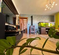 Living room in a family house with a fireplace, aquarium, and wooden details.