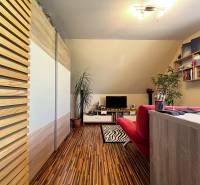 Office with wooden floor, red sofa, and desk, family house.