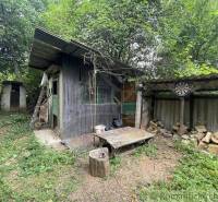 A wooden garden house with a shed in the yard of a family home in Branč.