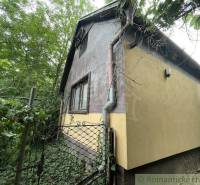 A family house in Branč surrounded by greenery with a gate and a gutter system.
