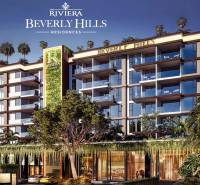 Apartment construction in Pattaya surrounded by greenery and palm trees, modern architectural design.