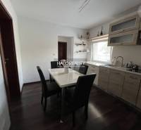 A dining room with wooden furniture and a dining table in a family house.