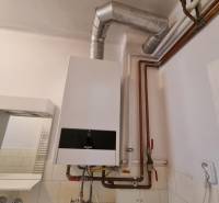 A gas boiler with connected pipes in the interior of a family house.
