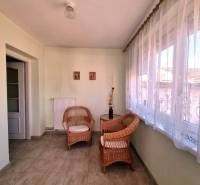 A spacious room in a family house with wicker furniture and elegant curtains.